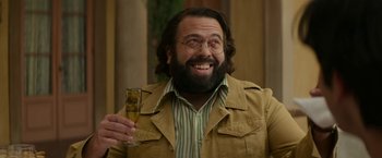 Movie still from “The Offer” (2022), directed by Dexter Fletcher – A bearded man holding a glass of champagne; Close Up shot, Low angle