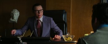 Movie still from “The Offer” (2022), directed by Dexter Fletcher – A man sitting at a desk in front of a bowl of candy; Medium shot, Low angle