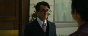 Movie still from “The Offer” (2022), directed by Dexter Fletcher – A man in a suit and tie standing in front of a window; Close Up shot, Low angle