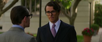 Movie still from “The Offer” (2022), directed by Dexter Fletcher – A man in a suit and tie standing next to another man in a suit; Close Up shot, Low angle