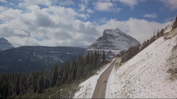 Movie still from “The Shining” (1980), directed by Stanley Kubrick – A car driving down a road on a mountain side covered in snow; Extreme Wide shot, High angle