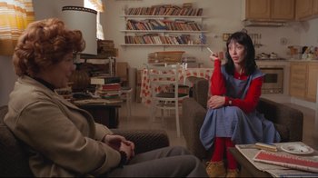 Movie still from “The Shining” (1980), directed by Stanley Kubrick – Two people sitting in a living room with a book shelf in the background; Medium shot, Over the shoulder angle