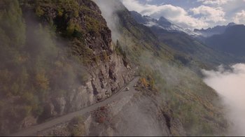 Movie still from “The Shining” (1980), directed by Stanley Kubrick – An aerial view of a mountain with a road going up the side of it; Extreme Wide shot, High angle