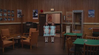 Movie still from “The Shining” (1980), directed by Stanley Kubrick – Two little girls standing next to each other in a room; Wide shot, High angle