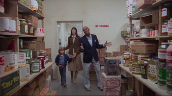 Movie still from “The Shining” (1980), directed by Stanley Kubrick – A man , woman , and child in a room filled with boxes; Wide shot, Low angle