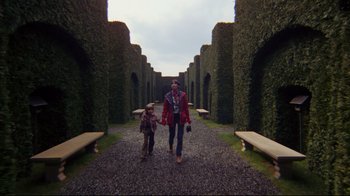 Movie still from “The Shining” (1980), directed by Stanley Kubrick – A man and a child walking down a path through a hedge; Wide shot, High angle