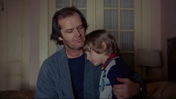 Movie still from “The Shining” (1980), directed by Stanley Kubrick – A man and a boy are looking at each other; Medium shot, Low angle