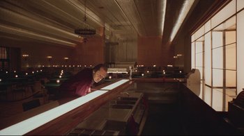 Movie still from “The Shining” (1980), directed by Stanley Kubrick – A man leaning over a counter in a restaurant; Wide shot, High angle