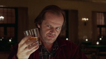 Movie still from “The Shining” (1980), directed by Stanley Kubrick – A man holding a glass of wine in his hand; Close Up shot, Low angle