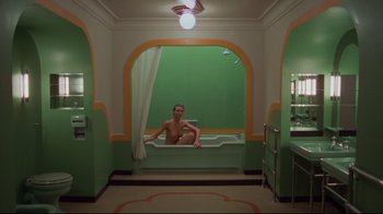 Movie still from “The Shining” (1980), directed by Stanley Kubrick – A man sitting in a bathtub in a bathroom; Wide shot, High angle