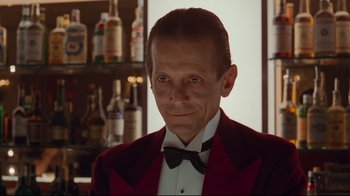 Movie still from “The Shining” (1980), directed by Stanley Kubrick – A person wearing a suit and bow tie; Close Up shot, Low angle