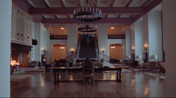 Movie still from “The Shining” (1980), directed by Stanley Kubrick – The lobby of a large hotel with a staircase and a chandelier; Extreme Wide shot, Low angle