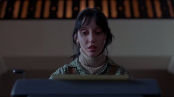 Movie still from “The Shining” (1980), directed by Stanley Kubrick – A woman sitting in front of a piano keyboard; Close Up shot, Low angle