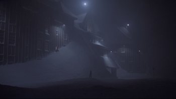 Movie still from “The Shining” (1980), directed by Stanley Kubrick – A person standing in the middle of a field in the dark; Extreme Wide shot, High angle