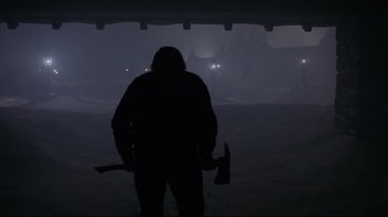 Movie still from “The Shining” (1980), directed by Stanley Kubrick – A person holding a axe in the dark; Wide shot, Low angle