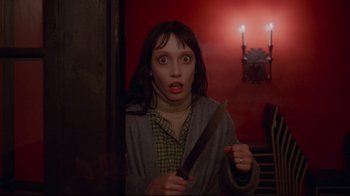Movie still from “The Shining” (1980), directed by Stanley Kubrick – A woman holding a knife in her hand; Close Up shot, Low angle