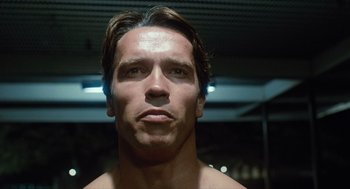 Movie still from “The Terminator” (1984), directed by James Cameron – A man's face in a dark room; Close Up shot, Low angle