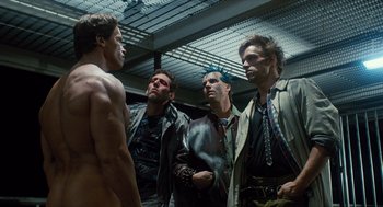 Movie still from “The Terminator” (1984), directed by James Cameron – A group of men standing next to each other in a room; Medium shot, Over the shoulder angle