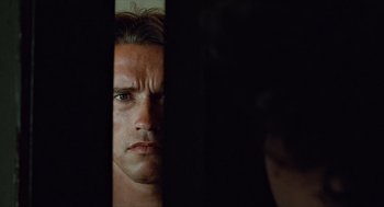 Movie still from “The Terminator” (1984), directed by James Cameron – A person looking through a window; Close Up shot, Low angle