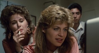 Movie still from “The Terminator” (1984), directed by James Cameron – A group of people that are sitting in a room together; Close Up shot, Over the shoulder angle