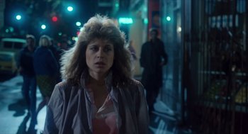 Movie still from “The Terminator” (1984), directed by James Cameron – A woman in a pink jacket standing on a sidewalk; Close Up shot, Over the shoulder angle