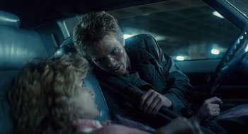 Movie still from “The Terminator” (1984), directed by James Cameron – A man sitting in the back of a car next to a woman; Close Up shot, Over the shoulder angle