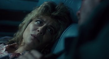 Movie still from “The Terminator” (1984), directed by James Cameron – A woman laying in the back seat of a car; Close Up shot, Over the shoulder angle