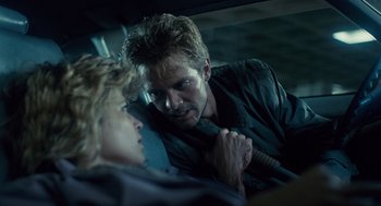 Movie still from “The Terminator” (1984), directed by James Cameron – A man and a woman sitting in the back of a car; Close Up shot, Over the shoulder angle