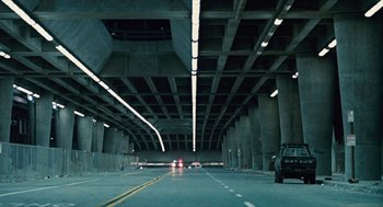 Movie still from “The Terminator” (1984), directed by James Cameron – An empty highway with a lot of lights on the ceiling; Extreme Wide shot, Low angle