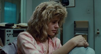 Movie still from “The Terminator” (1984), directed by James Cameron – A woman sitting on a couch looking down at the floor; Close Up shot, Over the shoulder angle