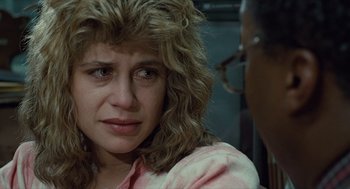 Movie still from “The Terminator” (1984), directed by James Cameron – A person with curly hair; Close Up shot, Over the shoulder angle