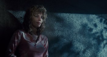 Movie still from “The Terminator” (1984), directed by James Cameron – A woman in a pink shirt is standing in front of a wall; Close Up shot, Low angle