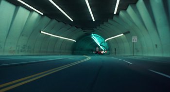 Movie still from “The Terminator” (1984), directed by James Cameron – A car driving down a street in a tunnel; Extreme Wide shot, High angle