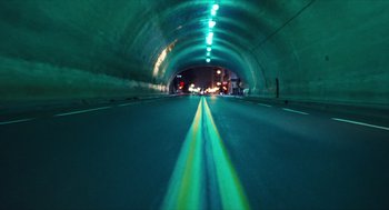 Movie still from “The Terminator” (1984), directed by James Cameron – A view of a tunnel from a car window at night time; Extreme Wide shot, High angle