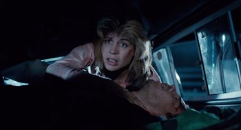 Movie still from “The Terminator” (1984), directed by James Cameron – A woman is holding a man in the back of a car; Close Up shot, Low angle