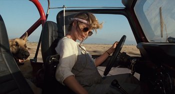 Movie still from “The Terminator” (1984), directed by James Cameron – A woman sitting in the driver's seat of a car; Medium shot, Low angle