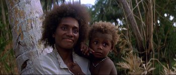 Movie still from “The Thin Red Line” (1998), directed by Terrence Malick – A woman and a child are posing for a picture; Close Up shot, High angle