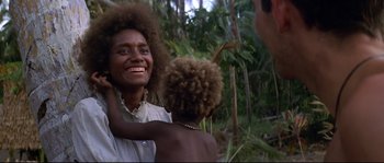 Movie still from “The Thin Red Line” (1998), directed by Terrence Malick – A woman smiles while holding a young child; Close Up shot, Over the shoulder angle