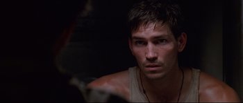 Movie still from “The Thin Red Line” (1998), directed by Terrence Malick – A person wearing a tank top; Close Up shot, Over the shoulder angle