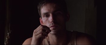 Movie still from “The Thin Red Line” (1998), directed by Terrence Malick – A person in a dark room; Close Up shot, Low angle