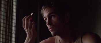Movie still from “The Thin Red Line” (1998), directed by Terrence Malick – A person holding a cigarette; Close Up shot, Low angle