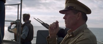 Movie still from “The Thin Red Line” (1998), directed by Terrence Malick – A man in a military uniform holding a cigarette; Close Up shot, Low angle