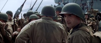 Movie still from “The Thin Red Line” (1998), directed by Terrence Malick – A group of men in military fatigues standing next to each other; Close Up shot, Low angle