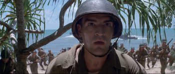 Movie still from “The Thin Red Line” (1998), directed by Terrence Malick – A man wearing a helmet standing next to a tree; Close Up shot, Low angle