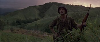 Movie still from “The Thin Red Line” (1998), directed by Terrence Malick – A man in a military uniform standing in a field; Medium shot, Low angle