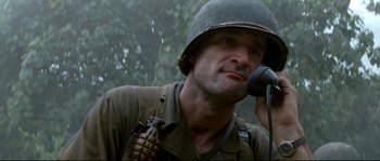 Movie still from “The Thin Red Line” (1998), directed by Terrence Malick – A man wearing a helmet and holding a gun; Close Up shot, Low angle