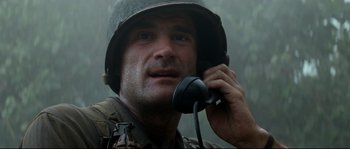 Movie still from “The Thin Red Line” (1998), directed by Terrence Malick – A man talking on a cell phone while wearing a helmet; Close Up shot, Low angle