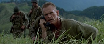 Movie still from “The Thin Red Line” (1998), directed by Terrence Malick – An older man on a phone in a field; Close Up shot, Low angle