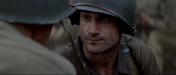 Movie still from “The Thin Red Line” (1998), directed by Terrence Malick – A person wearing a helmet; Close Up shot, Over the shoulder angle