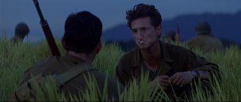 Movie still from “The Thin Red Line” (1998), directed by Terrence Malick – Two men are sitting in a field talking; Close Up shot, Over the shoulder angle